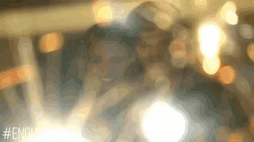 a blurry picture of a man and woman sitting next to each other in a car .