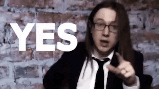 a man in a suit and tie is pointing at the word yes