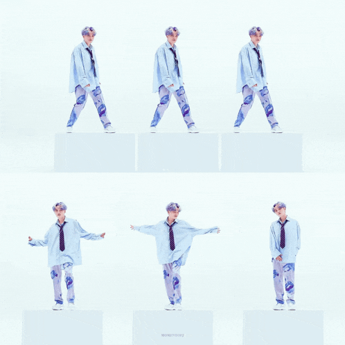 a man in a blue shirt and tie stands on a white cube