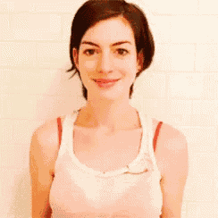 a woman in a white tank top with red straps