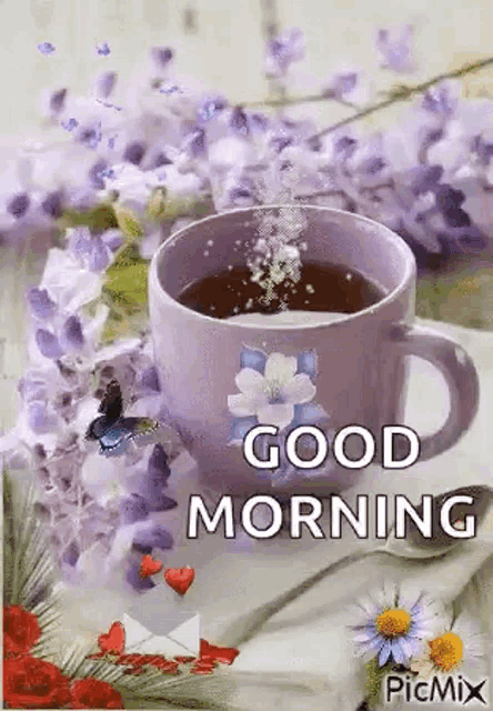 a cup of coffee is sitting on a table next to flowers and a butterfly .