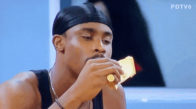 a man with a ring on his finger is eating a piece of bread