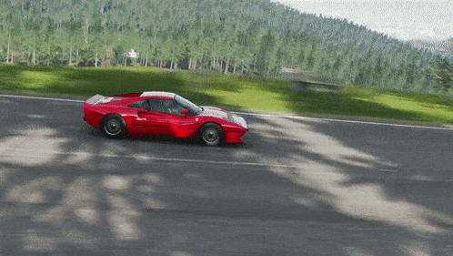 a red sports car is driving down a road surrounded by trees