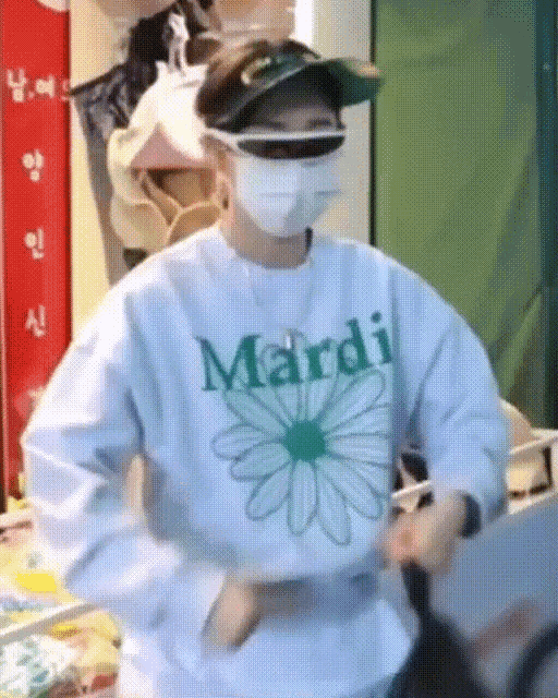 a man wearing a mask and a mardi sweatshirt