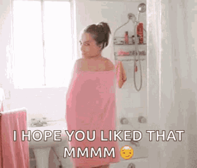 a woman wrapped in a pink towel is standing in a bathroom and saying `` i hope you liked that mmmm '' .