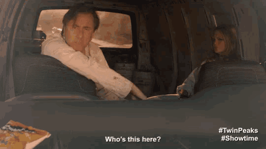 a man sitting in the back of a van talking to a woman who is sitting in the back seat