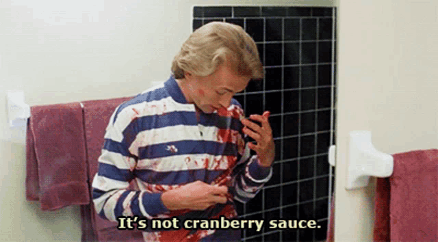 a man in a striped shirt says it 's not cranberry sauce in a bathroom