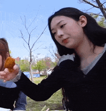 a woman holds a piece of food in her hand