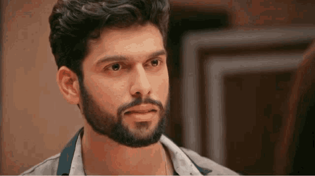 a close up of a man with a beard looking at a woman .