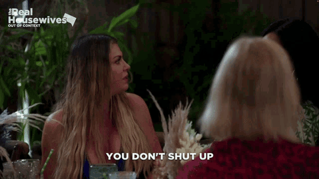 two women are sitting at a table and one of them is saying " you don t shut up "