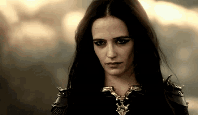 a close up of a woman wearing a necklace with a skull on it