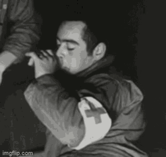 a man with a red cross on his sleeve