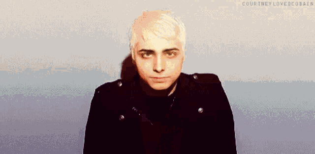 a young man with white hair is wearing a black jacket and a black shirt .