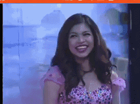 a woman in a pink dress is smiling in a video