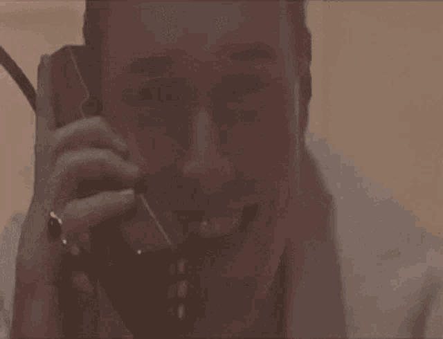 a man is laughing while talking on a cell phone