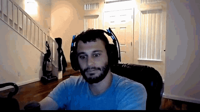 a man with a beard is wearing headphones and looking at the camera