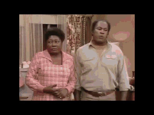 a man and a woman are standing in a living room .