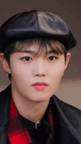 a close up of a young man wearing a hat