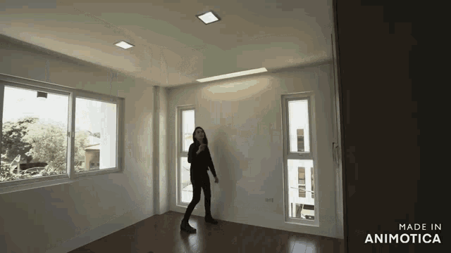 a woman is standing in an empty room with the words made in animotica above her