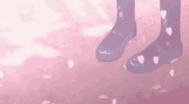 a person wearing a pair of blue shoes is standing on a pink surface with cherry blossom petals .