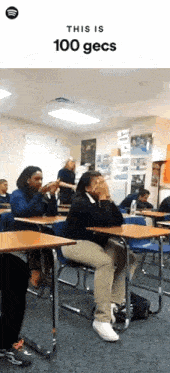 a group of people are sitting at desks in a classroom with the words this is 100 gecs on the top