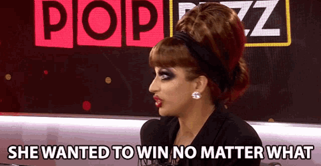 a woman says she wanted to win no matter what in front of a popbiz sign