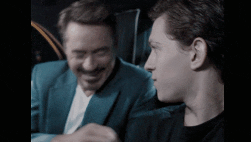 a man in a blue suit is laughing with another man