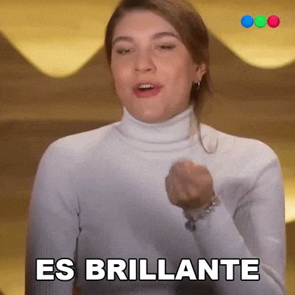a woman in a white turtleneck is making a fist and saying es brillante .