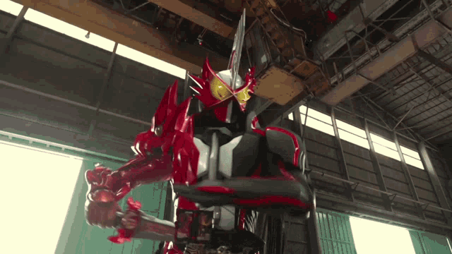 a man in a red and black costume is standing in a warehouse