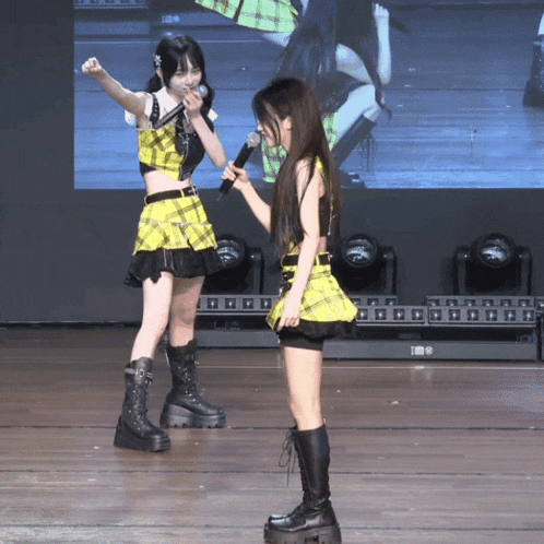 a girl in a yellow plaid top is holding a microphone
