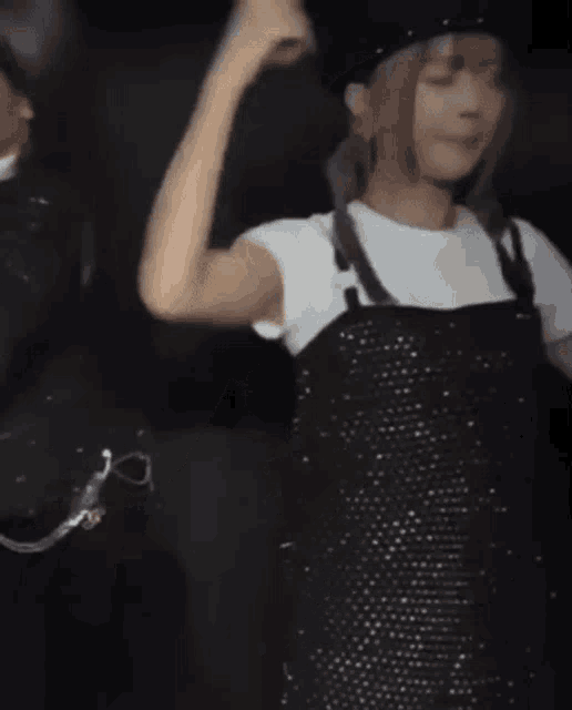 a woman in a black dress is dancing on a stage .