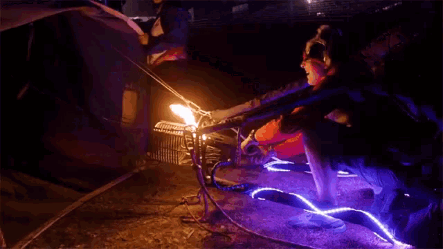 a person in a mask is sitting in front of a fire