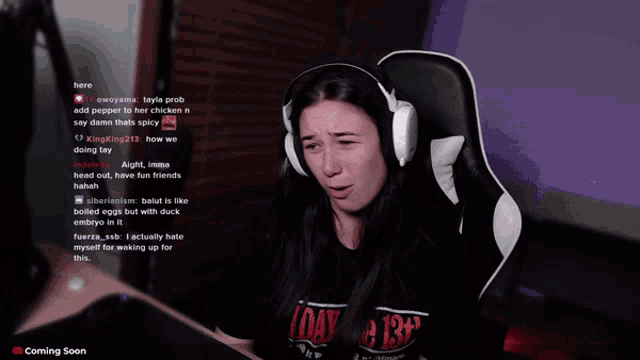 a woman wearing headphones sits in front of a computer screen with a purple background