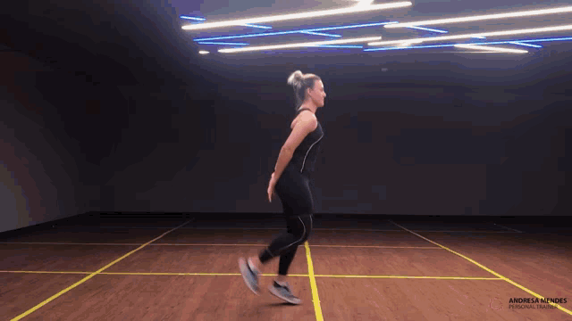 a woman is jumping on a wooden floor with andreas autoes personal trainer written on the bottom right