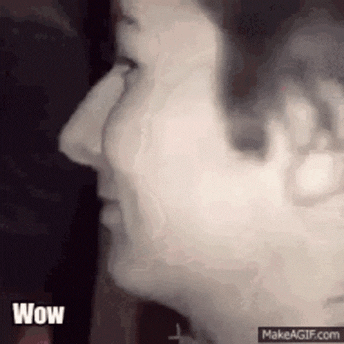 a close up of a person 's face with smoke coming out of their mouth .