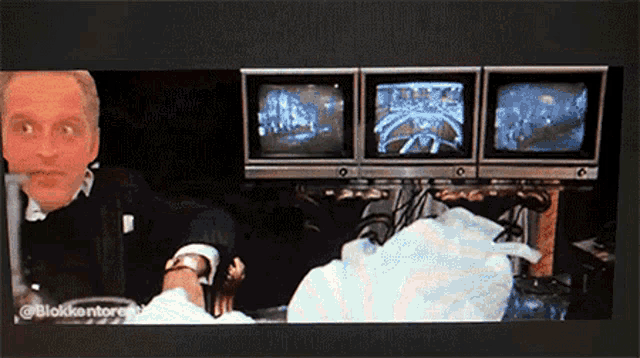 a man is sitting in front of three monitors with the hashtag @blokkontor on the bottom