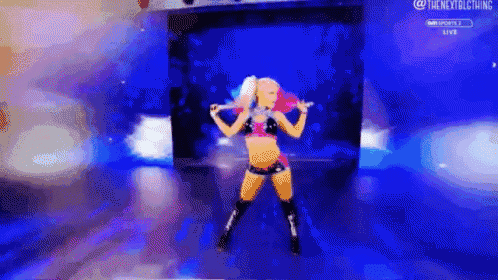 a female wrestler is dancing on a stage with a blue background .