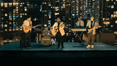 a band playing instruments on a stage with a drum set that says edgenote