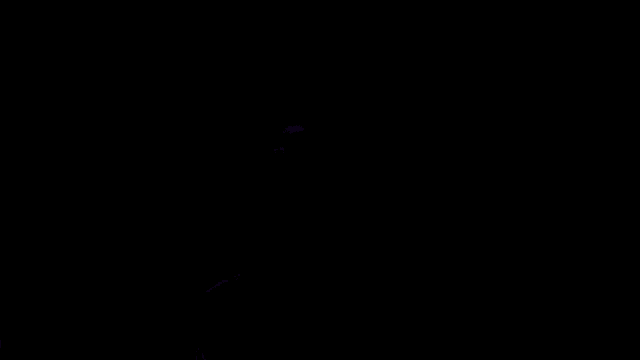 a man in headphones is holding a purple light saber in the dark .