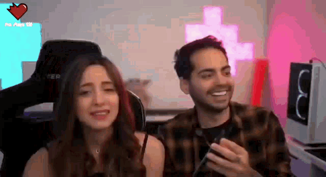 a man and a woman are sitting next to each other in a room .