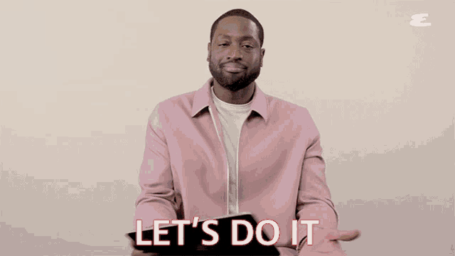 a man in a pink jacket is holding a tablet and says let 's do it