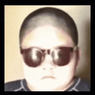 a blurry picture of a person wearing sunglasses and a shaved head .