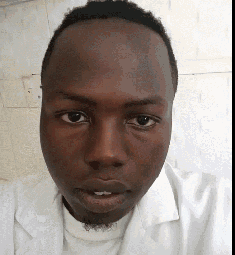 a close up of a man 's face with a white shirt