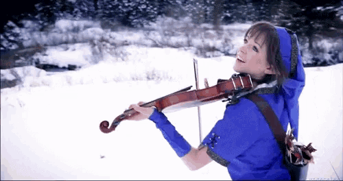 a woman playing a violin in the snow