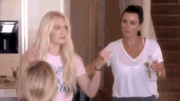 a group of women are standing next to each other in a kitchen .