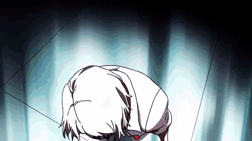 a person is kneeling down in a dark room with a red heart on their chest .