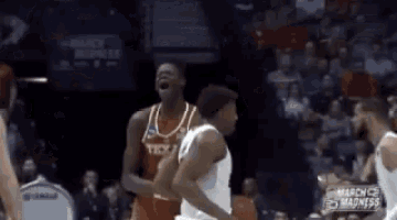 a group of basketball players are playing a game of basketball in a stadium .