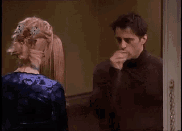a man and a woman are standing next to each other and talking .