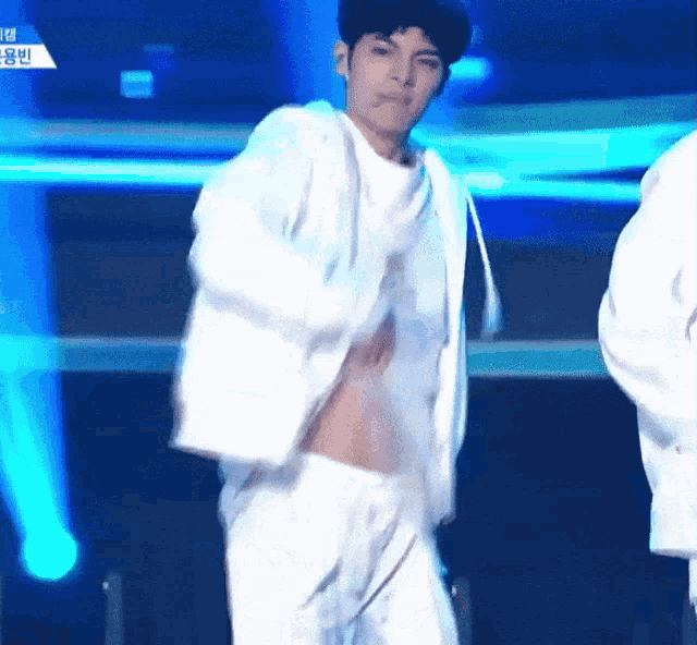 a man in a white shirt is dancing on a stage