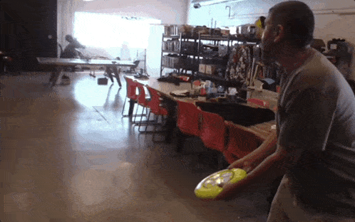 a man is throwing a frisbee in a warehouse
